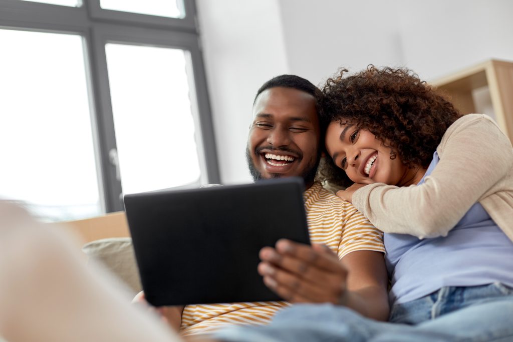 happy couple with tablet pc computer at new home