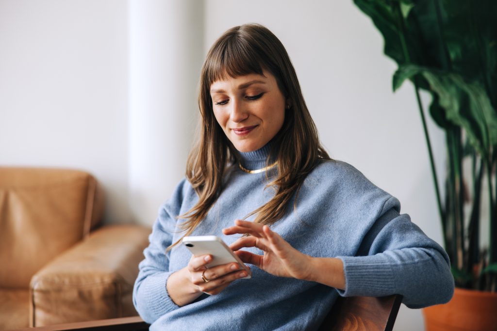 Businesswoman using a mobile phone in an office lobby