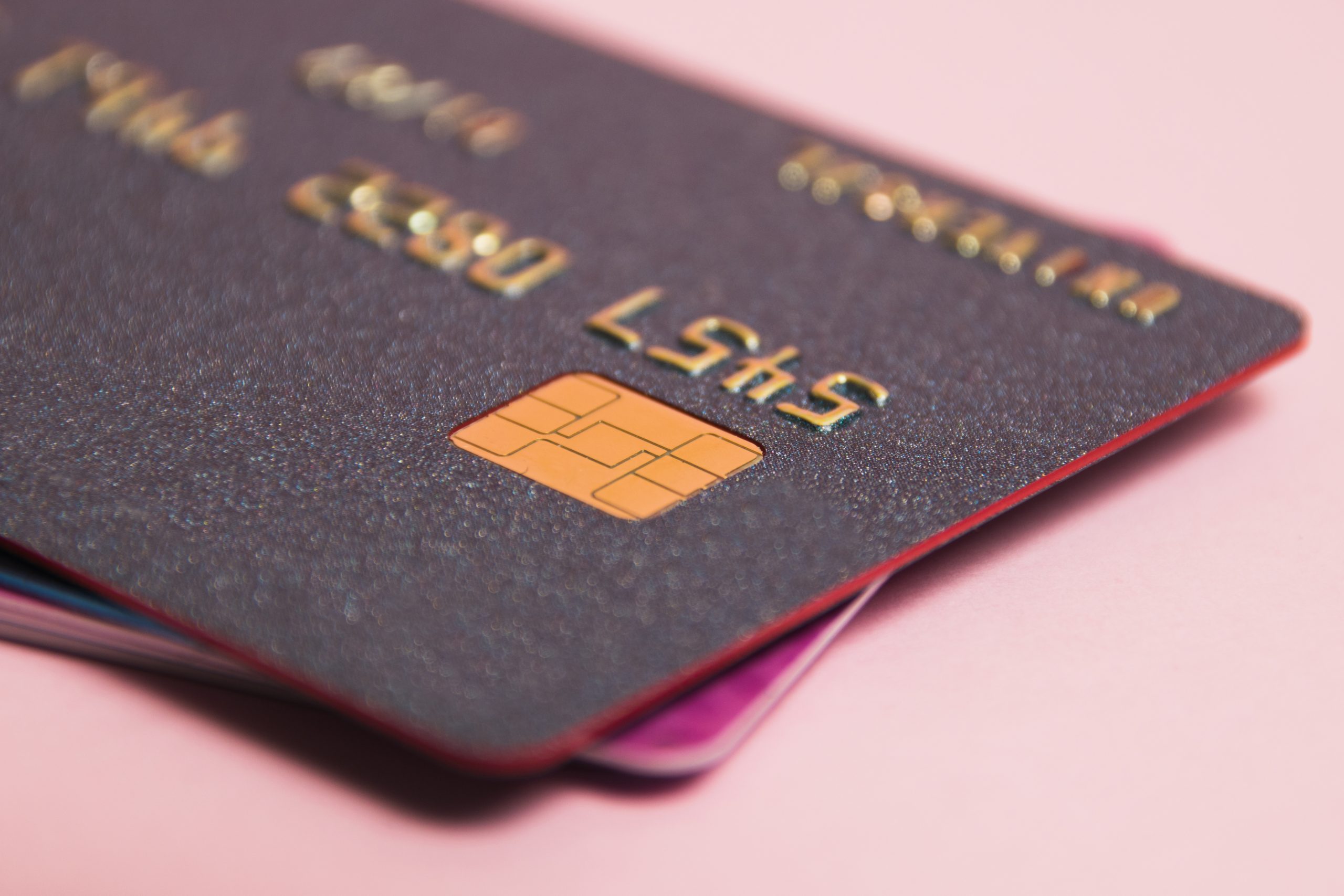 Modern bank cards with chips macro, credit cards on a pink background. The concept of bank card payments.