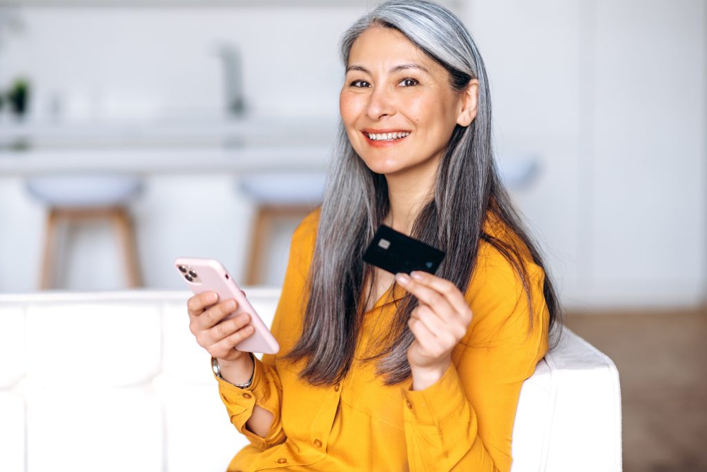 woman mature senior asian attractive gray-haired home cellphone shopping online credit card