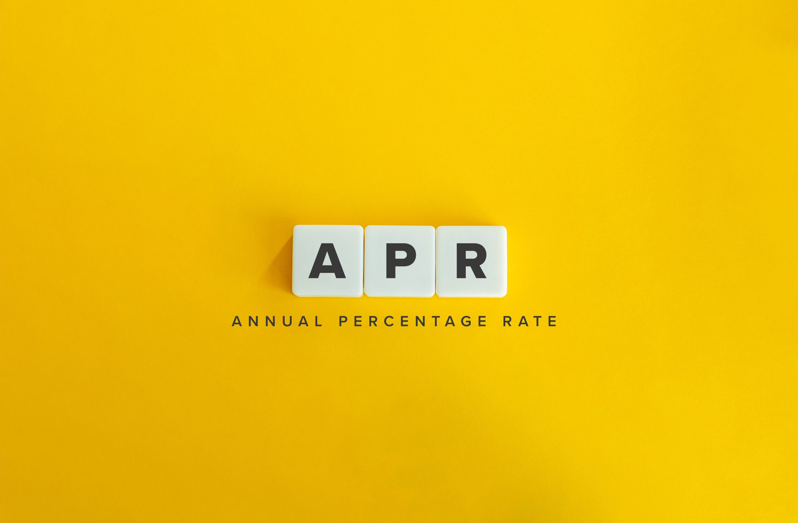Annual Percentage Rate (APR) Banner. Letter Tiles on Yellow Background. Minimal Aesthetics.