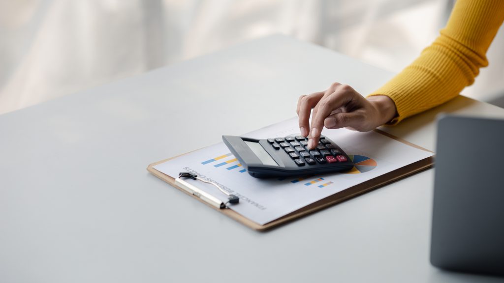 Businessman using a calculator to calculate numbers on a company